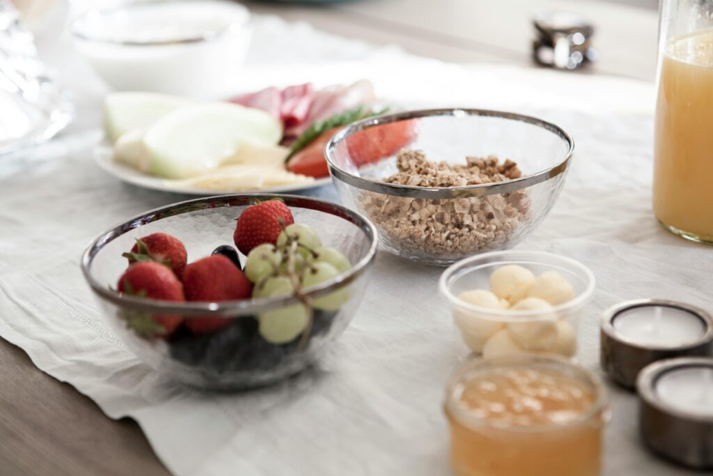 A delicious and nutritious breakfast spread featuring fresh fruits, granola, and juice on a dining table.
